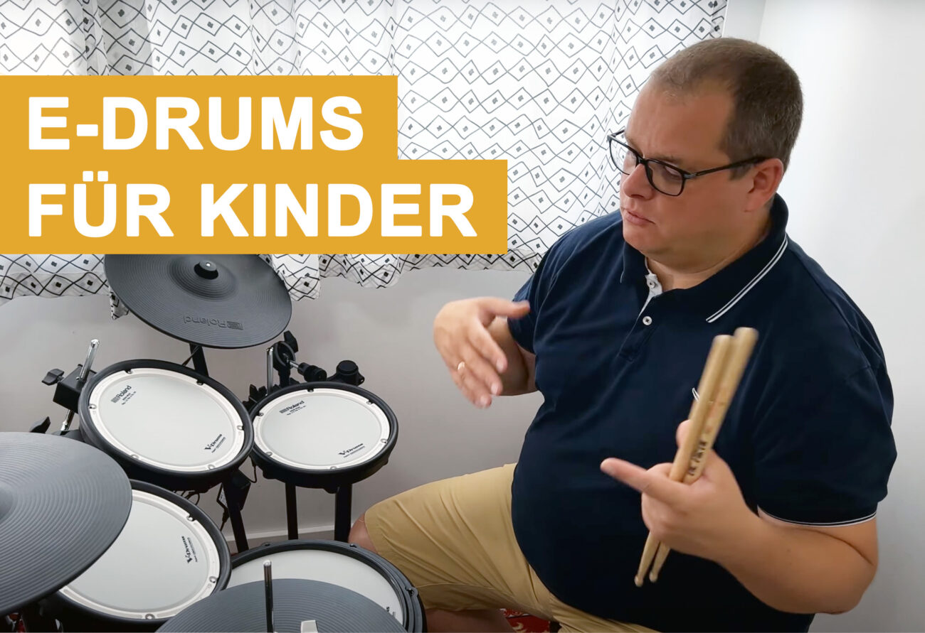 Schlagzeuglehrer mit Drumsticks neben elektronischem Schlagzeug mit Text-Overlay 'E-DRUMS FÜR KINDER